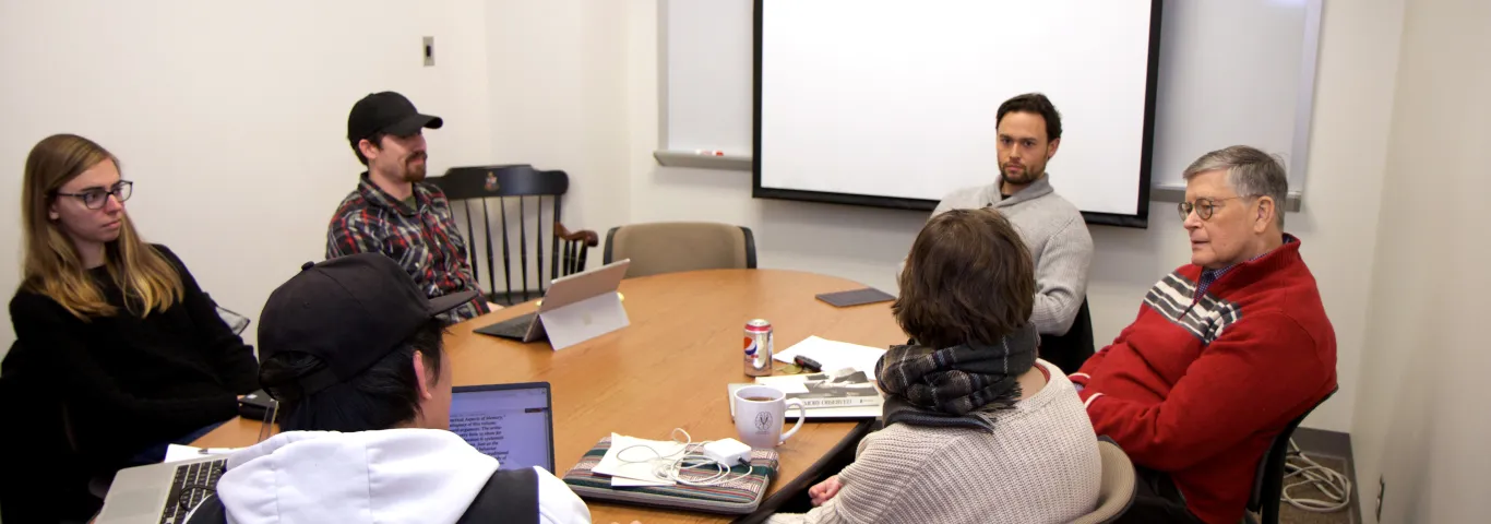 students and professors sitting around a table